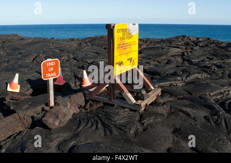 Ende des Weges. Schwarze Lava-Gebirge in der Nähe der Küste und der Autobahn Chain of Crater Road. Hawaii Volcanoes National Park. Big Island. Stockfoto