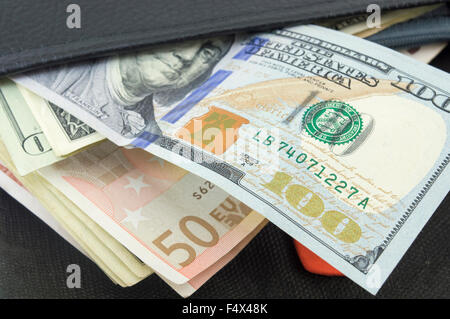 Verschiedenen Euro und Dollar-Scheine in eine schwarze Geldbörse Stockfoto