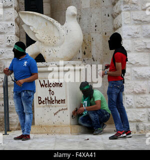 Bethlehem, Palästina. 23. Oktober 2015. Drei maskierte palästinensische Jugend stehen neben einer Taube des Friedens Klangskulptur und ein Zeichen, das liest, "Welcome to Bethlehem" während der Demonstrationen in der Stadt Besichtigung Bank. Gewaltsame Auseinandersetzungen zwischen palästinensischen Jugendlichen und israelischen Soldaten weiter in den meisten Städten im Westjordanland. In Bethlehem palästinensische Jugend marschierte auf die israelischen militärischen Kontrollpunkt und kollidierte mit israelischen Soldaten wieder. Bildnachweis: Anna Ferensowicz/Pacific Press/Alamy Live-Nachrichten Stockfoto