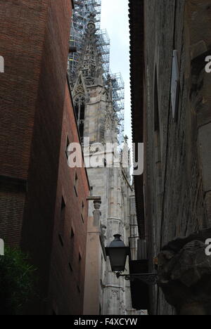 Kirchturm mit Gerüst aus einer engen Straße zwischen zwei alte Wohnhäuser in Madrid betrachtet. Stockfoto