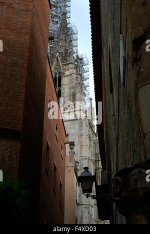 Kirchturm mit Gerüst aus einer engen Straße zwischen zwei alte Wohnhäuser in Madrid betrachtet. Stockfoto