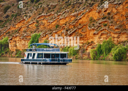 Hausboot Cruisen am Murray River vor hohen Klippen. Stockfoto