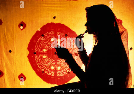 Silhouette einer jungen hindu Frau wer setzt Schmink-(Indien) Stockfoto