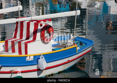 Nahaufnahme eines traditionellen hölzernen Fischerboot und surreale Landschaft spiegelt sich auf der Meeresoberfläche. Myrina Kai, Limnos, Griechenland Stockfoto