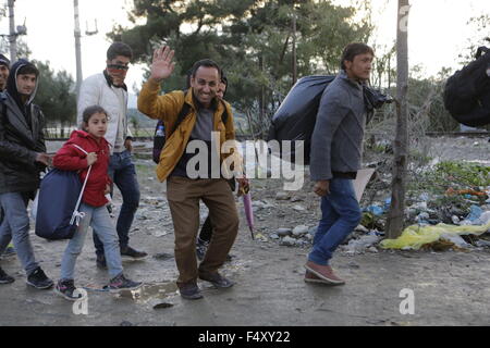 Idomeni, Griechenland. 23. Oktober 2015. Ein Flüchtling winkt in die Kamera während der Überquerung der Grenze mit der Republik Mazedonien. Tausende Flüchtlinge überqueren die Grenze zwischen Griechenland und Mazedonien täglich um die kleine griechische Stadt Idomeni, trotz der sich verschlechternde Wetter und starkem Regen. Hier nehmen sie einen kurzen Stopp für einige Vorräte und warten ihrerseits auf die Grenze zu überqueren. Bildnachweis: Michael Debets/Pacific Press/Alamy Live-Nachrichten Stockfoto