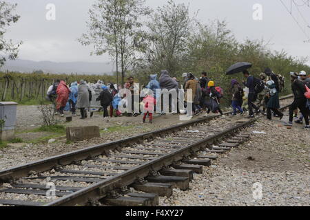 Idomeni, Griechenland. 23. Oktober 2015. Flüchtlinge überqueren die Bahnlinie auf der mazedonischen Seite der Grenze. Tausende Flüchtlinge überqueren die Grenze zwischen Griechenland und Mazedonien täglich um die kleine griechische Stadt Idomeni, trotz der sich verschlechternde Wetter und starkem Regen. Hier nehmen sie einen kurzen Stopp für einige Vorräte und warten ihrerseits auf die Grenze zu überqueren. Bildnachweis: Michael Debets/Pacific Press/Alamy Live-Nachrichten Stockfoto