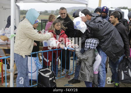 Idomeni, Griechenland. 23. Oktober 2015. Freiwillige hand Bestimmungen für die kommenden Flüchtlinge. Tausende Flüchtlinge überqueren die Grenze zwischen Griechenland und Mazedonien täglich um die kleine griechische Stadt Idomeni, trotz der sich verschlechternde Wetter und starkem Regen. Hier nehmen sie einen kurzen Stopp für einige Vorräte und warten ihrerseits auf die Grenze zu überqueren. Bildnachweis: Michael Debets/Pacific Press/Alamy Live-Nachrichten Stockfoto