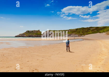 Eine weibliche Walker am einsamen Strand von Broadhaven, Pembrokeshire, Wales, UK Stockfoto