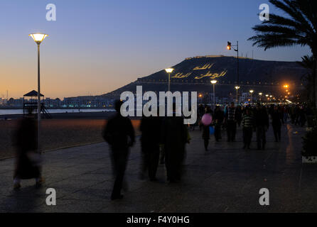 Menschen zu Fuß am Strand von Agadir bei Sonnenuntergang Stockfoto