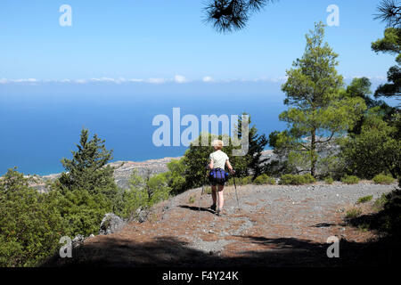 Zurück Blick auf Frau Rucksack & Wasser flaschen alleine Wandern Wandern auf einen Tag im September, Blick auf das Meer an der Küste von Nord Zypern KATHY DEWITT zu Stockfoto