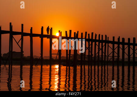 Einsamer Mönch U Bein Brücke, eine 1,2 km lange Teakholz Brücke bei Sonnenuntergang zu überqueren. Amarapura, Mandalay Region, Myanmar (Burma). Stockfoto