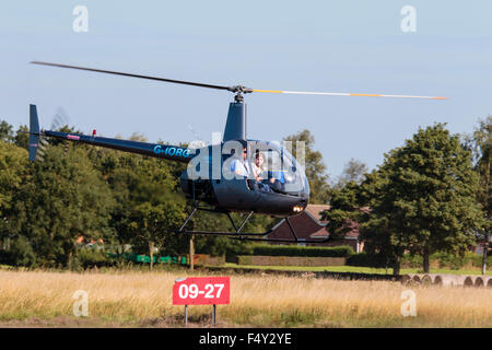 Robinson R22 Beta G-IORG im Flug am Sturgate Flugplatz Stockfoto