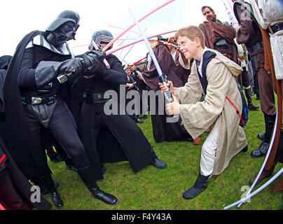London, UK. 24. Oktober 2015. Darth Vader aus Star Wars nimmt auf einen jungen Jedi-Ritter in einem Lichtschwert-Kampf am MCM London Comic Con in Excel London Credit: Paul Brown/Alamy Live News Stockfoto
