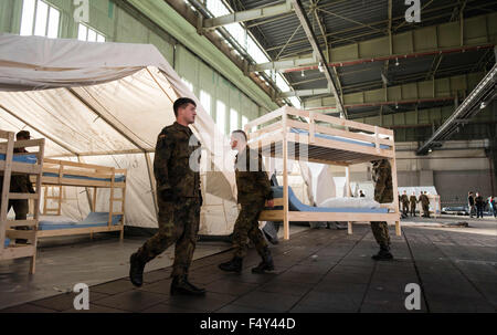 Berlin, Deutschland. 24. Oktober 2015. Deutsche Bundeswehr-Soldaten tragen Etagenbetten in einem Hangar auf dem ehemaligen Flughafen Tempelhof, wo ein Auffanglager für Flüchtlinge in Berlin, Deutschland, 24. Oktober 2015 eingerichtet wird. Foto: GREGOR FISCHER/Dpa/Alamy Live News Stockfoto