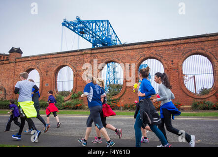 Middlesbrough, UK. 24. Oktober 2015. 2,5 Meile geführte Kunst laufen einige der Middlesbrough Kunsträume und historische Sehenswürdigkeiten zu besuchen. Bild: Läufer nähert sich die Abschläge Schwebefähre. Die Tees Schwebefähre wurde ein Symbol der Gegend seit der Eröffnung im Jahr 1911. In Großbritannien gibt es nur zwei andere Transporter Bridges noch im bestehen. Diese Brücken sind in Newport (Gwent), 1906 eröffnet und Warrington, 1916 eröffnet. Bildnachweis: Alan Dawson News/Alamy Live-Nachrichten Stockfoto