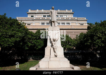 Marmorstatue von Charilaos / Harilaos Trikoupis und dem alten griechischen Parlament Gebäude / National History Museum im Hintergrund Stockfoto