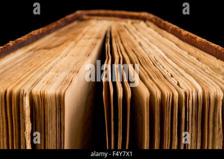 altes Buch geschossen auf schwarzem Hintergrund. Das Buch ist in einem schlechten Zustand. Stockfoto