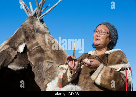 Kanada, Nunavut, der Hudson Bay, Kivalliq, Arviat, lokale Frau zeigt historische Werkzeuge, die von den Inuit verwendet, polar Zelt im Hintergrund. Stockfoto