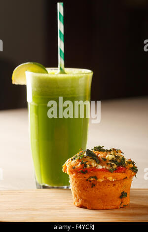 Nahaufnahme von einem Gemüse-Muffin (Spinat und Paprika) mit frisch gepressten Saft aus Äpfeln, Avocados, Spinat Stockfoto