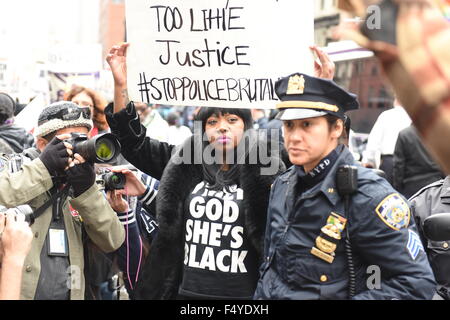 Aktivist mit Hand beschriftet Zeichen stehen neben uniformierten NYPD Offizier. Mehr als tausend Aktivisten marschierten im Namen der Familien der Opfer von angeblicher Polizeigewalt in "Rise Up Oktober". (Foto: Andy Katz / Pacific Press) Stockfoto