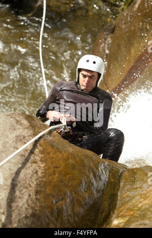 Erwachsene Mann Absteigend einer ecuadorianischen Wasserfall in die richtige Position Stockfoto