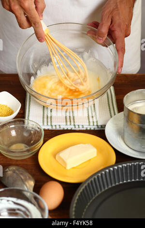 Saure Creme Zitronenkuchen machen. Schlagen, Zucker, saurer Sahne und Eiern. Stockfoto