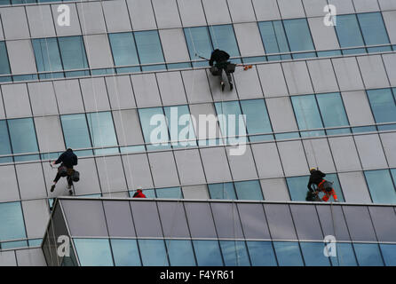 Arbeitnehmer sind Reinigung Windows vor Bürogebäude Stockfoto