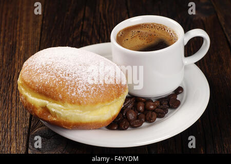 Berliner Krapfen mit Tasse heißen Kaffee auf dunklen Holztisch Stockfoto