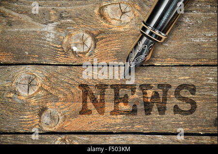 Füllfederhalter und Wort News geschrieben auf Vintage Holz-Hintergrund Stockfoto