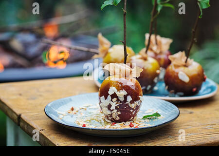 Toffee Äpfel und ein Lagerfeuer im Hintergrund Stockfoto