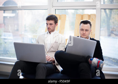 Männer, die mit Laptops im Gründerzentrum Stockfoto