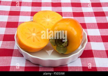 Kaki-Frucht in zwei Hälften geschnitten Stockfoto