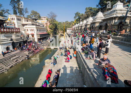 Zuschauer, die eine feuerbestattung Zeremonie am Burning ghats in der Nähe von Pashupatinath Tempel Stockfoto