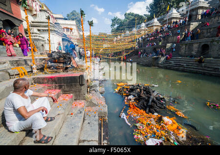 Burning ghats mit laufenden einäscherung in der Nähe von Pashupatinath Tempel, Dekorationen der Hari bodari akdshi Messe im Hintergrund Stockfoto