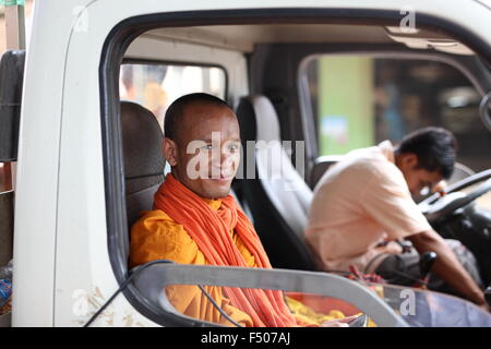 Mönch auf Beifahrerseite der linken Hand getrieben von LKW in Kambodscha mit mit Handy in seinen Händen. Fahrer aus dem Fokus. Stockfoto