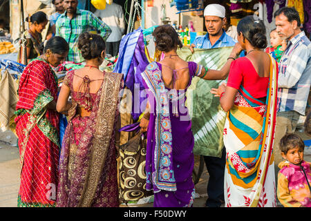 Einige Frauen in Saris kaufen Material mit einem straßenverkäufer Shop Stockfoto