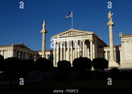 Weiten Blick auf die Akademie von Athen Gebäude und Statuen von Athen (links) und Apollo mit Silhouette Bäume im Vordergrund. Griechenland Stockfoto