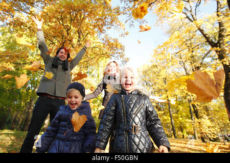 Glückliche Familie spielen mit Herbst Ahorn Blätter im park Stockfoto