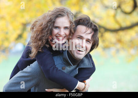 Lächelnde paar umarmt im Herbst Park auf gelben Ahorn Baum Hintergrund Stockfoto