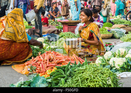 Eine Frau verkauft, Karotten, Peperoni und Blumenkohl auf dem wöchentlichen Gemüsemarkt Stockfoto
