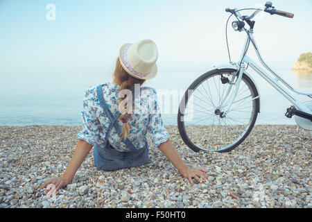 Glückliche Frau mit dem Fahrrad am Strand - Blick von der Rückseite Stockfoto