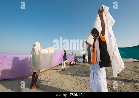 Einige Pilger, Frauen und Männer, sind Trocknen ihre Saris und Tücher nach der Badewanne und betet im heiligen Fluss Yamuna Stockfoto