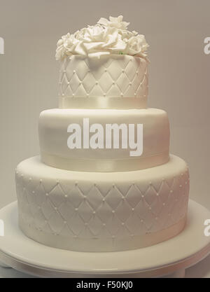 Details zu einer Hochzeitstorte, Dekoration mit weißen Fondant auf weißem Hintergrund. Stockfoto