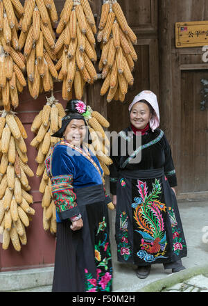 Zwei Dorf Frau in traditioneller Kleidung mit dem Trocknen von Mais Maiskolben, Langde Shang Miao Dorf, Guizhou Provinz, China Stockfoto