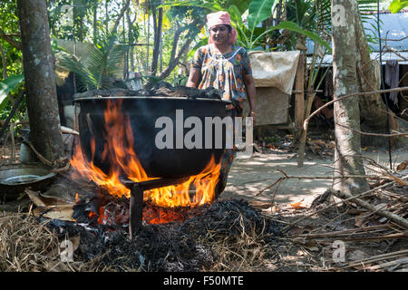 Eine Frau kocht Muscheln in einem großen Pott auf offenem Feuer Stockfoto