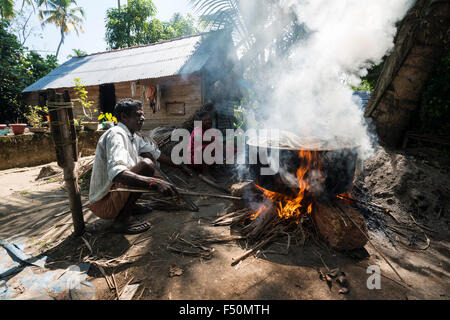 Ein Mann kocht Muscheln in einem großen Pott auf offenem Feuer Stockfoto