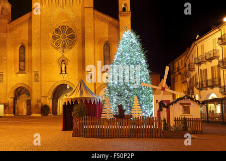 Große beleuchtete Weihnachtsbaum am Hauptplatz und die Kathedrale San Lorenzo im Hintergrund am Abend in Alba, Norditalien. Stockfoto