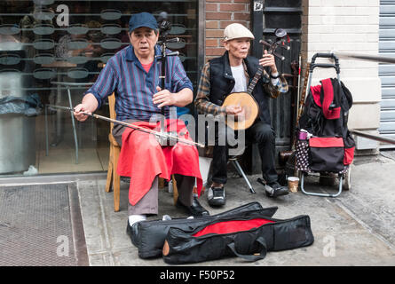 Zwei hochrangige asiatische Buskermusiker, die chinesische Musik auf Erhu spielen Und ruan in Chinatown in New York City Stockfoto