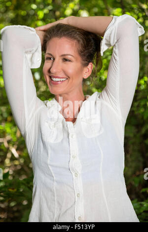 Schöne glückliche Frau, die im Sommer im Freien genießen Stockfoto