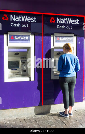 Eine junge Frau von einem Natwest Bank ATM oder Geldautomaten Bargeld abheben Stockfoto